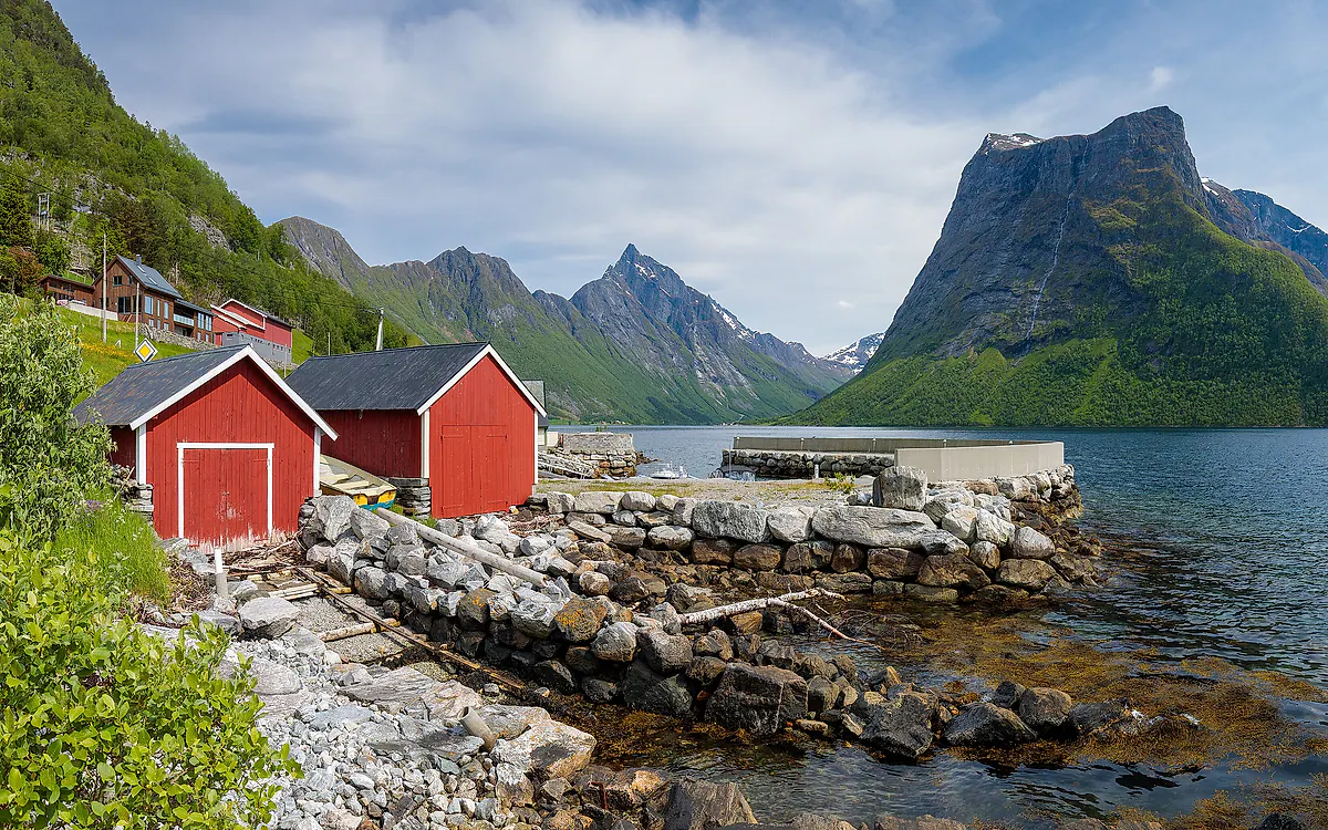 Røde naust og fjell ved Hjørundfjorden i Ørsta