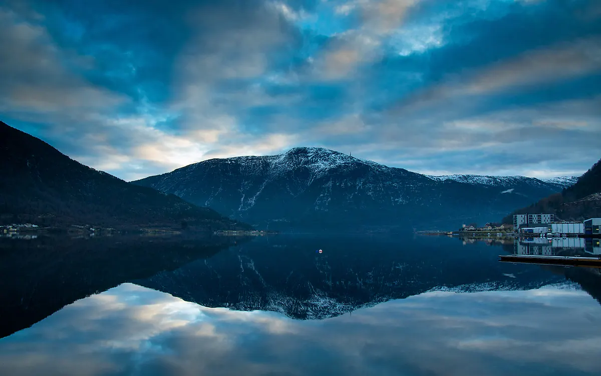 Sogndalsfjorden med snødekte fjell speilet i vannet