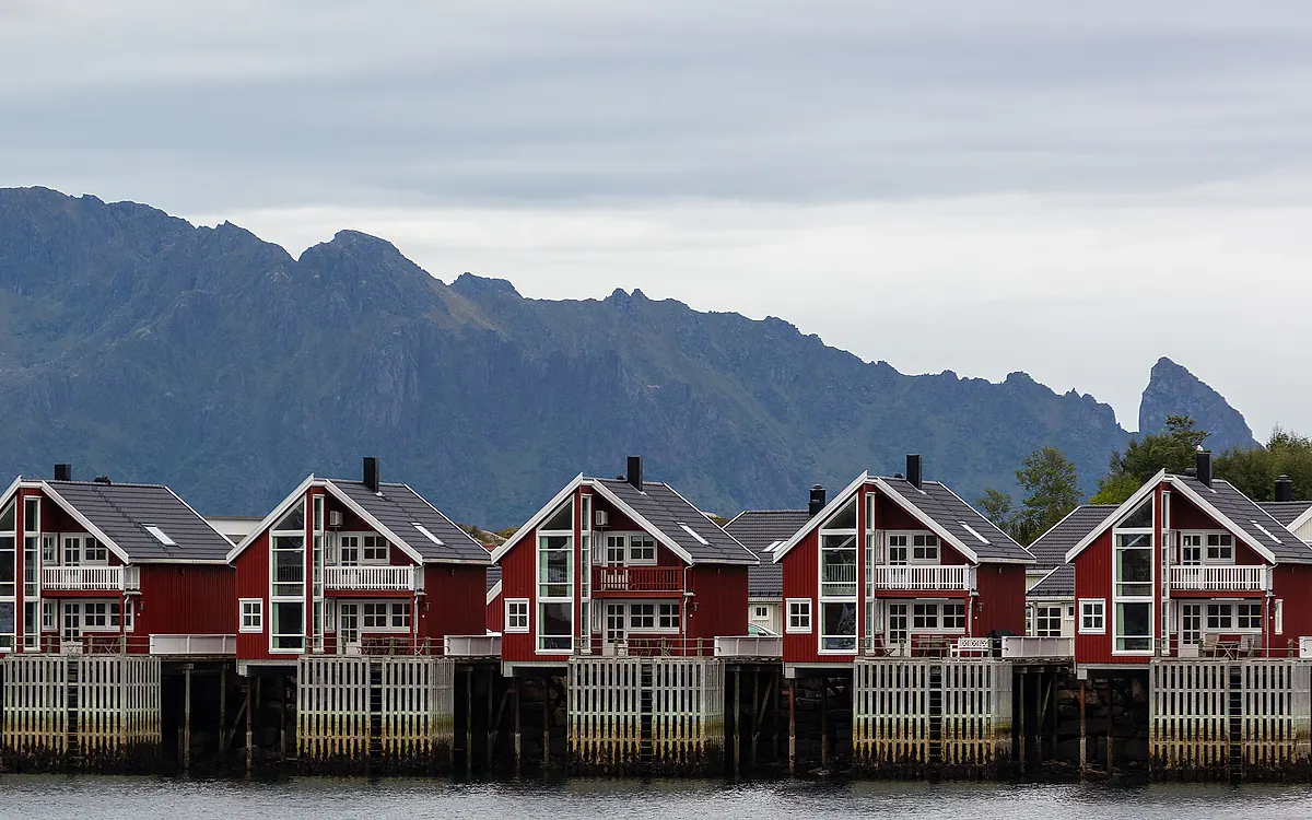 Røde rorbuer i Svolvær under fjellene